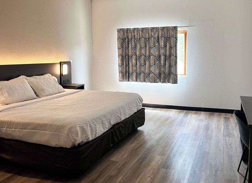 Studio 6 Suites Elkhart, IN guest room with king bed, window and wood-look flooring