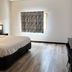 Studio 6 Suites Elkhart, IN guest room with king bed, window and wood-look flooring