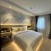 Mingcheng Hotel Beijing guest room with bed, bedside tables, wall-mounted TV and window curtains