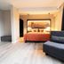 JustStay Mülheim an der Ruhr guest room with bed, lounge chair and city-view window