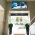 Residencial Lar do Areeiro entrance in Lisbon with glass doors, potted topiary, and stair railings