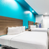 Scottish Inns & Suites - Kingwood guest room in Humble with two beds and turquoise accent wall