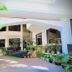 Hotel Devi Grand, Katra: covered courtyard entrance with potted tropical plants and steps to glass doors