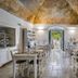 Palazzo Ducale Venturi in Minervino di Lecce, vaulted dining room with set tables and open doorway to garden