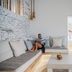 Levantes Ios Boutique Hotel in Mylopotas: bright suite with curved sofa, skylight, and stone accent wall