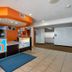 Motel 6 El Paso - Southeast lobby with front desk, orange accents, tile floor and blue entry mat
