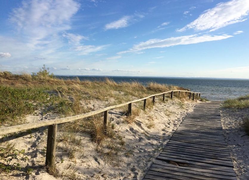 Hotel Jastarnia in Jastarnia: wooden beach path through dunes to the sea under a blue sky