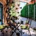 La Villa Des Violettes in Toulouse: garden patio with wrought-iron chairs, tables, and umbrellas