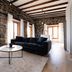 Maison Place Royale by Luxury In Transit in Montreal, stone-walled suite with sofa, armchair and round coffee table