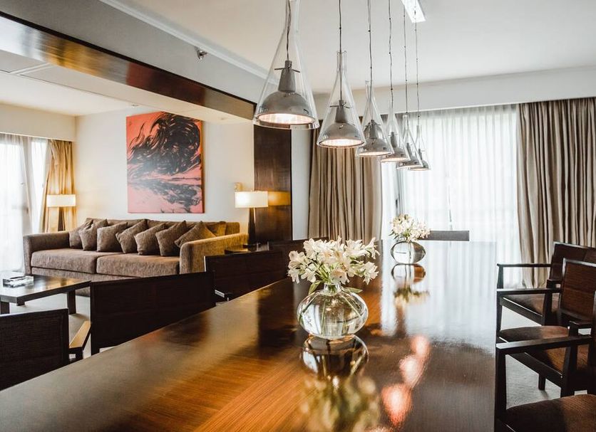 Sheraton Salta Hotel in Salta dining area with polished wooden table, pendant lights, and lounge seating