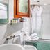 Hotel La Pergola bathroom in Lignano Sabbiadoro with shower, towels, robes and green tile