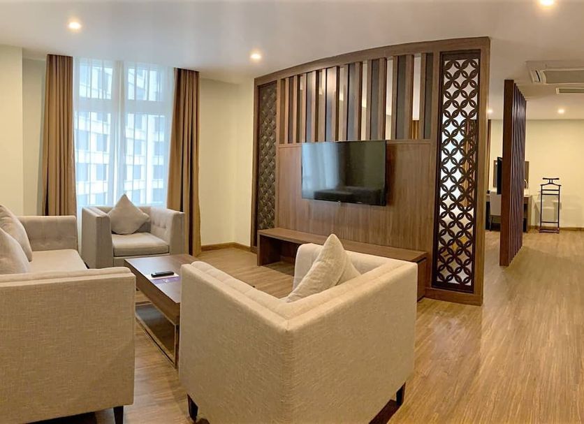 Muong Thanh Luxury Lang Son Hotel living room suite with TV, sofas, and wood partition in Lang Son