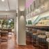 Calamos Beach Family Club in Agii Apostoli lobby bar with stools, tables and bright garden views