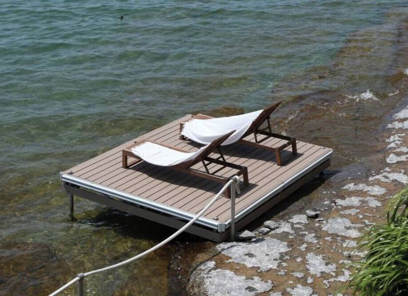 The Lakeside Prince Edward County waterfront deck with two lounge chairs by the water