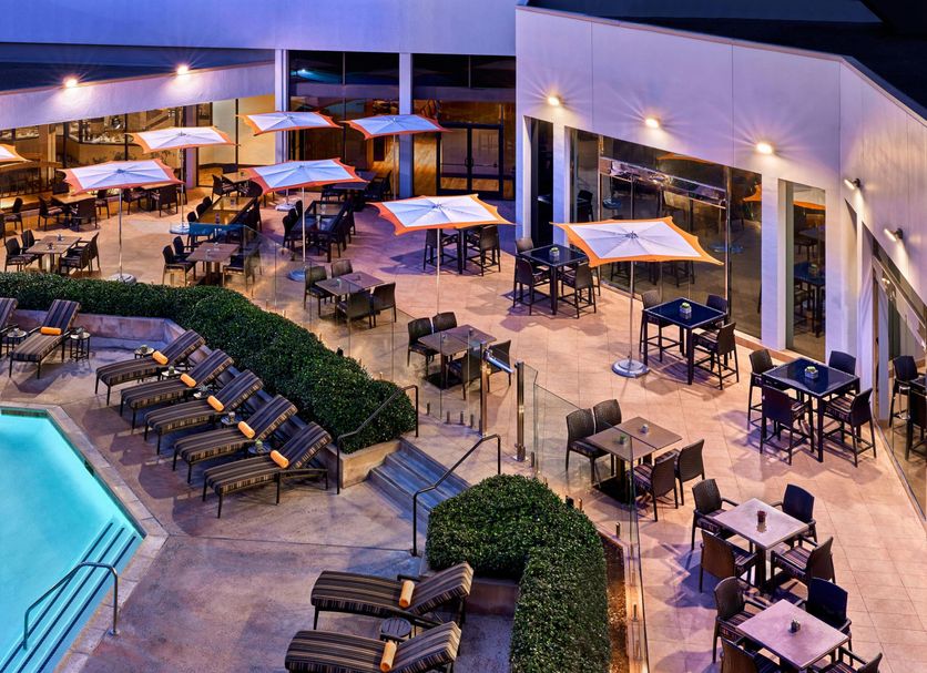 Anaheim Marriott poolside terrace with loungers, tables and umbrellas beside the outdoor pool in Anaheim