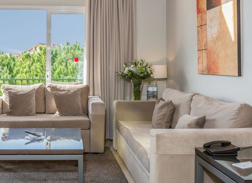 Ona Alanda Club Marbella in Marbella living room with sofa, coffee table and balcony garden view
