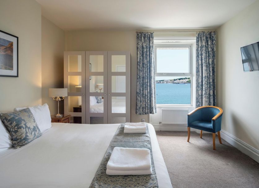 Grand Hotel Swanage room with sea view, blue chair, and window overlooking Swanage coast