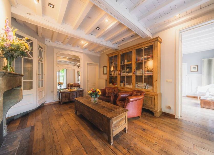 Number 11 Exclusive Guesthouse Bruges lounge with leather chairs, wooden table and hardwood floors