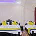 Hilltown Hotel, Madikeri room with two beds, purple ceiling lighting, and red curtains