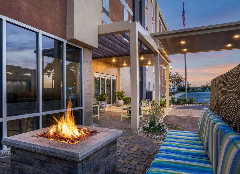 Home2 Suites by Hilton Biloxi North/D'Iberville patio with fire pit and striped seating at sunset
