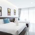 Phranang Place- Sha Extra in Krabi, bright guest room with two beds, wall-mounted TV and balcony curtains