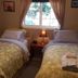 The Grateful Bed B'n'B in Prince George guest room with two twin beds, bedside lamp, and window