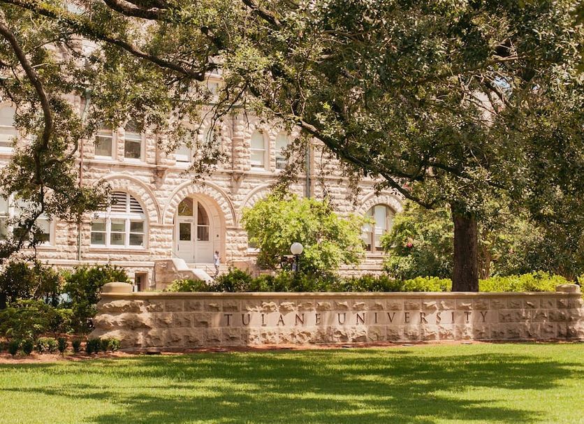 Historic Streetcar Inn in New Orleans with stone facade, arched windows, and landscaped front lawn