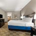 Americas Best Value Inn Byhalia guest room with king bed, TV, dresser and seating area