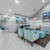 Baymont by Wyndham Tuscaloosa lobby seating area with teal chairs, sofa, and pendant lighting