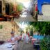 Vintage Alacati in Alacati: stone courtyard dining, colorful street, and windmills under blue sky