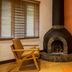 Villa Blanca Cloud Forest Hotel + Retreat in San Ramón: cozy room with fireplace, wood chair, and window blinds