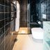 Hôtel Le Mosaïque in Narbonne bathroom with black tiled walls, walk-in shower and wall-mounted toilet