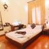 A25 Hotel Mai Hac De guest room in Hanoi with a bed, desk, wardrobe and polished wood floor.