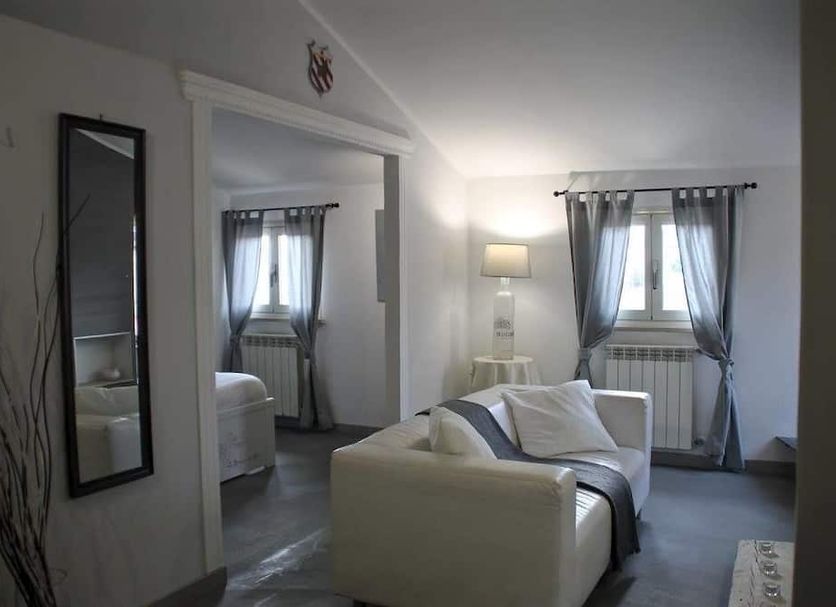 Antica Corte del Castello in Fiano Romano guest room with sofa, mirror, and window drapes