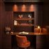 Rosewood Vienna study nook with warm wood paneling, desk lamp, shelf decor and orange chair in Vienna.