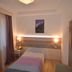 Hotel Centrale guest room in Auronzo di Cadore with single bed, bedside lamps and mountain wall art