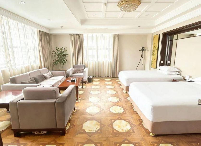 Elite Hotel Xi'an in Xi'an guest room with two beds, seating area, and large windows
