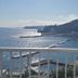 Atami Onsen Guest House Megumi in Atami with a balcony view of the bay, beach, and mountains