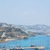 Rhenia Hotel in Tourlos with a scenic bay view, sailboats, and hillside buildings along the coast