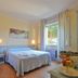 Hotel Massimo, Cecina: bright guest room with twin beds, window view, and small table with fruit