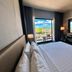 Le Charme Suites Subic in Olongapo: guest room with balcony view, bed, and desk