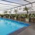 Yogi Executive, Navi Mumbai rooftop pool with city views, palm trees and outdoor seating