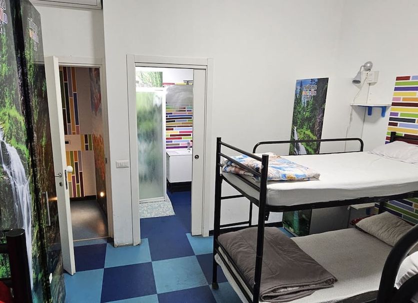Milano Ostello in Milan dorm room with bunk beds, blue checkered floor and waterfall mural