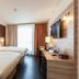 Staycity Aparthotels Heidelberg room with two beds, desk, wall-mounted TV and window light