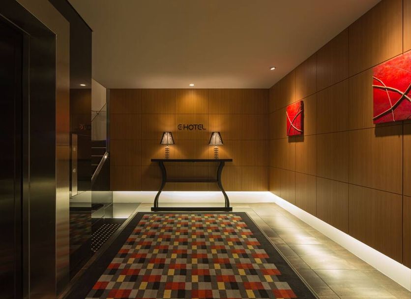 E Hotel Higashi Shinjuku lobby in Tokyo with wood-paneled walls, red art, and patterned carpet