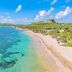 Coconut Bay Resort in Vieux Fort with a turquoise beach, palm-lined shore, and coastal hills