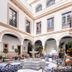 Hotel Casa Palacio Don Ramón in Seville courtyard with arched colonnades, fountain, and seating