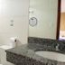 Rede Andrade Hangar in Belém: bathroom with granite sink vanity, mirror, toilet and glass shower