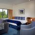 Saxton Lodge Nelson guest room with king bed, sofa, chair and large window views