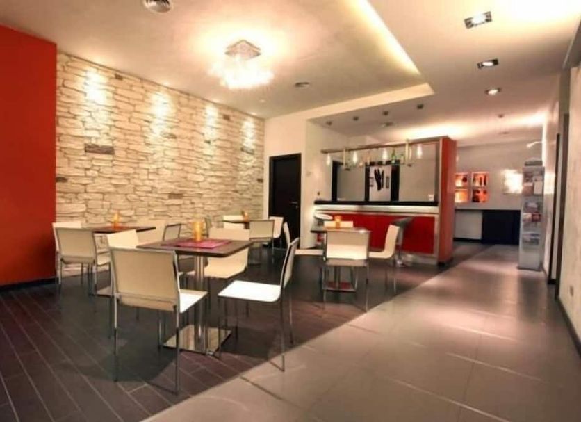Miramonti Potenza hotel breakfast area with tables, chairs, stone accent wall and buffet counter